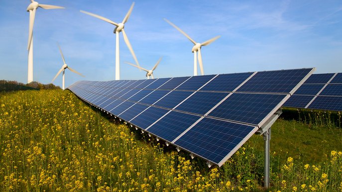 Solarpanels und Windräder auf blühendem Feld. Symbol für Energieerzeugung durch Sonne und Wind.