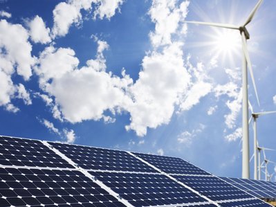 Solaranlage und Windkraftanlagen bei blauem Himmel; kombinierte Stromerzeugung aus Sonne und Wind, nachhaltig und klimafreundlich.