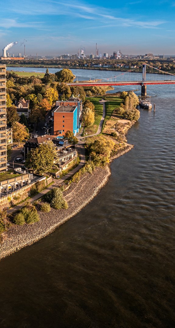 Luftaufnahme der Stadt Duisburg und den Rhein. Viele grüne Bäume stehen für Ökostrom Duisburg.
