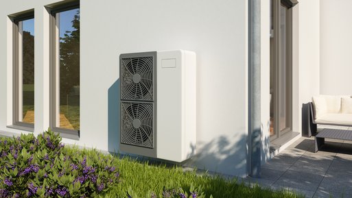 Wärmepumpe an sonniger Hausfassade, umgeben von Blumenbeeten. Starke Kombination mit Gasheizung für nachhaltiges Heizen.