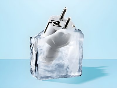 Bild zeigt einen Eisklotz mit einem eingefrorenen Steckdosenstecker – Thema: Stromverbrauch von Gefrierschränken.
