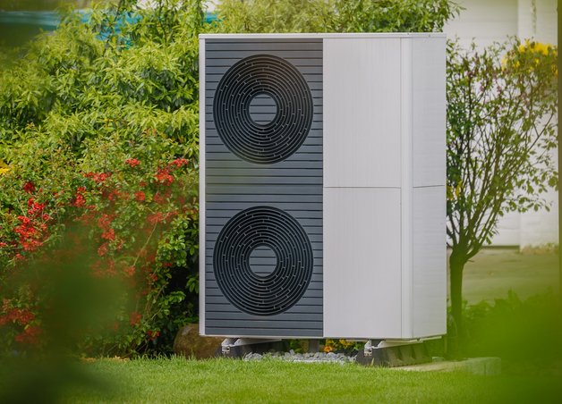 Bild zeigt eine Wärmepumpe im Garten – die Kosten für Anschaffung und Betrieb sind wichtige Aspekte bei der Entscheidung für eine Wärmepumpe.