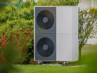 Bild zeigt eine Wärmepumpe im Garten – die Kosten für Anschaffung und Betrieb sind wichtige Aspekte bei der Entscheidung für eine Wärmepumpe.