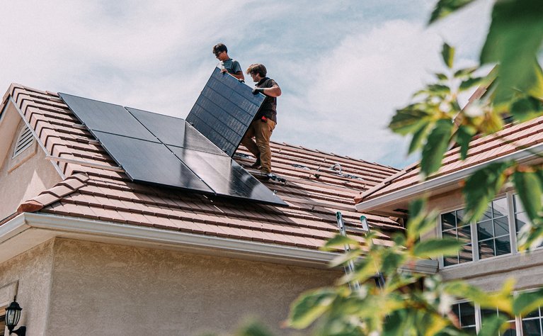 "Zwei Arbeiter installieren Solarmodule auf einem Hausdach. Symbolisiert die Vermarktung von Ökostrom nach EEG durch ENTEGA. "