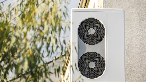 Außeneinheit einer Wärmepumpe, seitlich von Blättern eingerahmt. Kontext: Dynamische Tarife bieten Vorteile bei schwankenden Strompreisen.