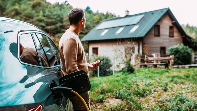 Bild zeigt einen Mann, der sein Elektroauto mit Strom aus seiner Photovoltaikanlage lädt.