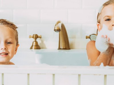 Bild zeigt zwei Kinder in der Badewanne, Symbolbild für Warmwasser mit Solarthermie