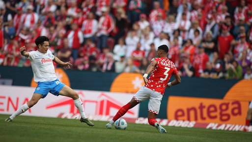 Zwei Fußballer im Zweikampf vor ENTEGA-Werbebanner, verdeutlicht die langjährige Unterstützung des 1. FSV Mainz 05 durch ENTEGA.