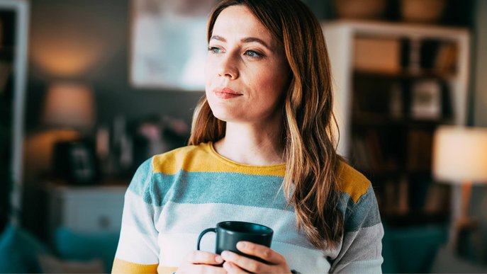 Bild zeigt eine nachdenkliche Frau mit Tasse in der Hand, als Symbolbild für die Frage „Was ist der Brennwert von Gas?“