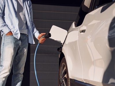 Bild zeigt Person beim Laden des Elektroautos. Es geht um die Wallbox-Förderung und verschiedene Zuschüsse. 