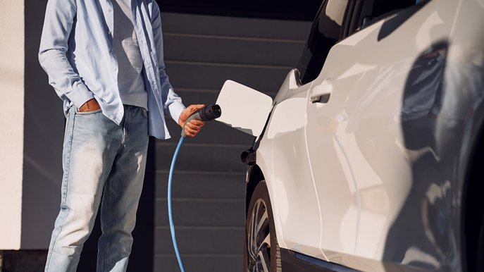 Bild zeigt Person beim Laden des Elektroautos. Es geht um die Wallbox-Förderung und verschiedene Zuschüsse. 