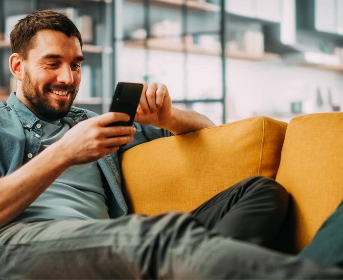 Bild mit lächelndem Mann, der auf ein Smartphone schaut, Link: Tarif berechnen