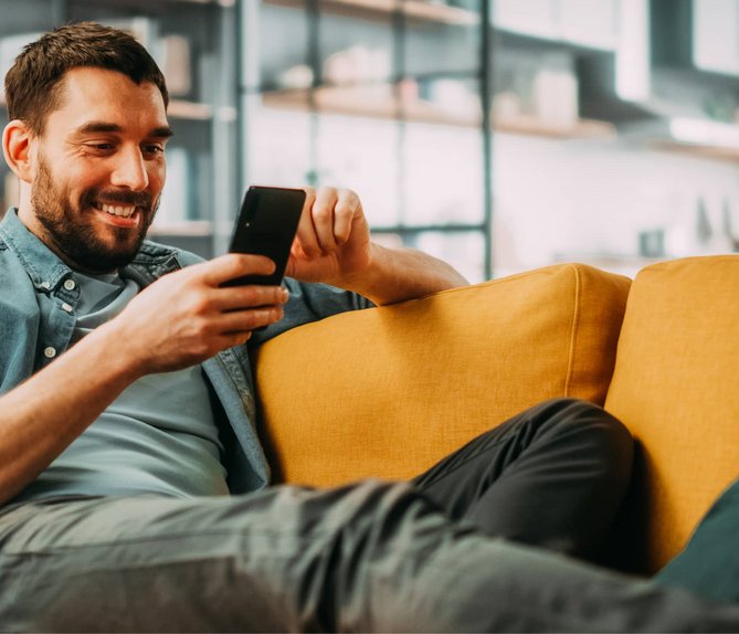 Bild mit lächelndem Mann, der auf ein Smartphone schaut, Link: Tarif berechnen