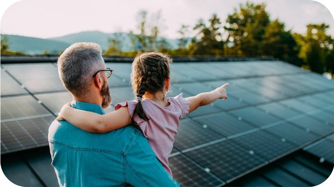 Bild zeigt Mann mit Kind vor einer Solaranlage