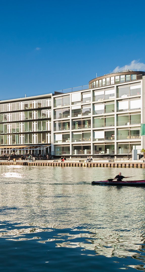 Moderne Büro- und Wohngebäude am Wasser in Münster, Symbol für nachhaltige Stadtentwicklung mit Ökostrom Münster.