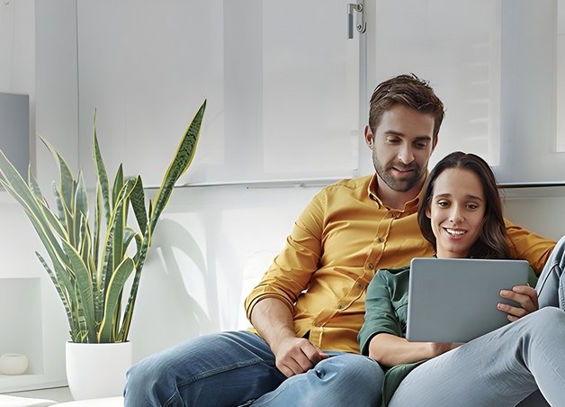 Bild zeigt Paar, das gemeinsam in einen Laptop schaut – Thema: Worauf man beim Stromanbieter achten sollte.