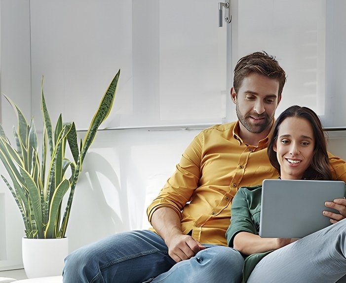Bild zeigt Paar, das gemeinsam in einen Laptop schaut – Thema: Worauf man beim Stromanbieter achten sollte.