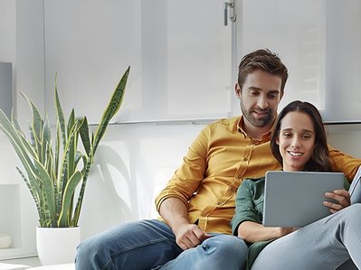 Bild zeigt Paar, das gemeinsam in einen Laptop schaut – Thema: Worauf man beim Stromanbieter achten sollte.