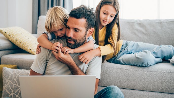 Familie auf Sofa, konzentriert auf Laptop. Darstellung der einfachen Verwaltung des ENTEGA Vertrags in vertrauter Umgebung.