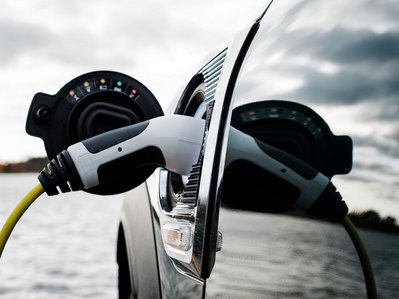 Bild zeigt ein Elektroauto beim Laden – wie viel Strom ein E-Auto auf 100 km verbraucht, hängt unter anderem vom Modell und der Fahrweise ab.