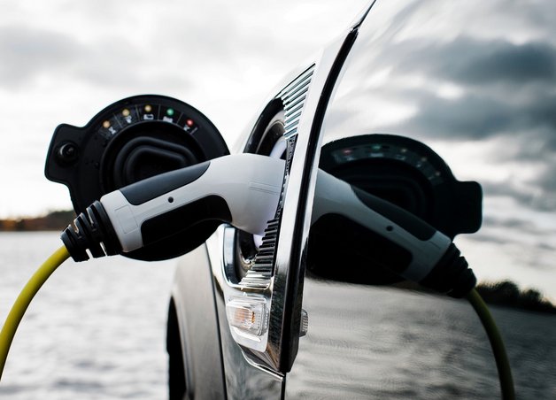 Bild zeigt ein Elektroauto beim Laden – wie viel Strom ein E-Auto auf 100 km verbraucht, hängt unter anderem vom Modell und der Fahrweise ab.
