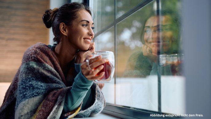 Frau am Fenster, Teetasse in der Hand – ein Moment voller Harmonie und Ruhe