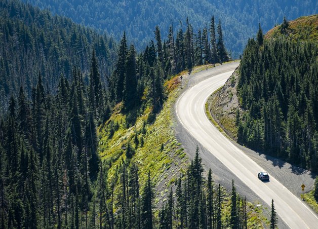 Bild zeigt einen Bergpass mit kurviger Straße – bergige Strecken können die Reichweite eines E-Autos beeinflussen.