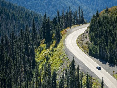 Bild zeigt einen Bergpass mit kurviger Straße – bergige Strecken können die Reichweite eines E-Autos beeinflussen.
