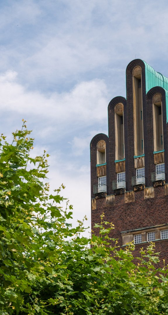 Hochzeitsturm in Darmstadt unter blauem Himmel. ENTEGA als klimafreundlicher Ökostromanbieter in Darmstadt.