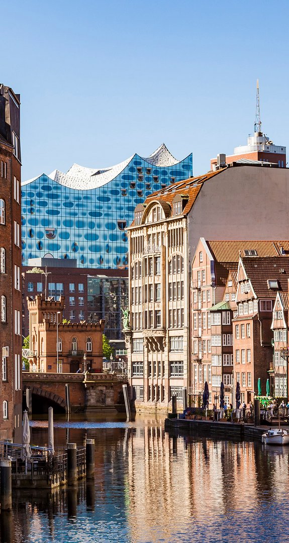 Kanäle von Hamburg mit Backsteinhäusern, Elbphilharmonie im Hintergrund. ENTEGA als klimafreundlicher Ökostromanbieter in Hamburg.