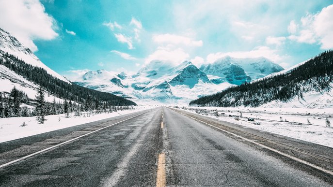 Bild illustriert das Thema E-Auto-Reichweite im Winter mit einer Straße in winterlicher Landschaft