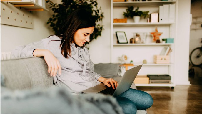 Stimmungsbild zeigt eine nachdenkliche Frau mit Tablet auf dem Sofa