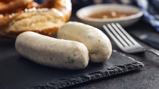 Nahaufnahme von Weißwürsten, serviert mit Brezel und Senf. Typisch bayerische Spezialität.