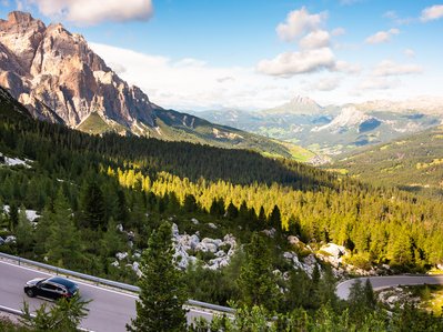 Schwarzer Pkw fährt auf kurvenreicher Bergstraße; natürliche Umgebung betont Elektroauto Ökobilanz im alpinen Kontext.