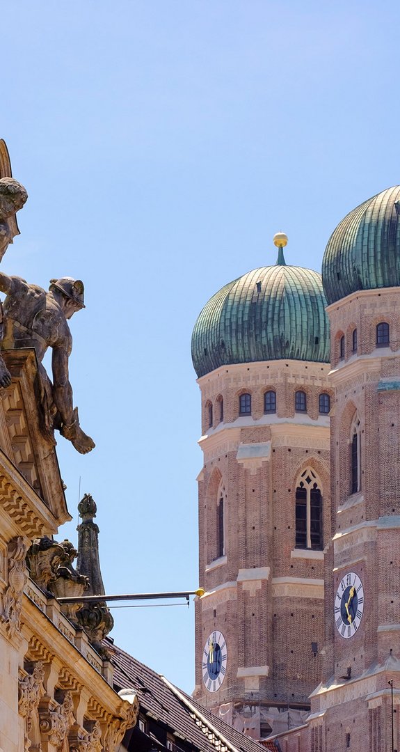 Frauenkirche in München zwischen verzierten Altbauten. ENTEGA als klimafreundlicher Ökostromanbieter in München.