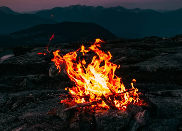 Bild zeigt ein Lagerfeuer in natürlicher Umgebung – es geht um die Geschichte der Heizung.