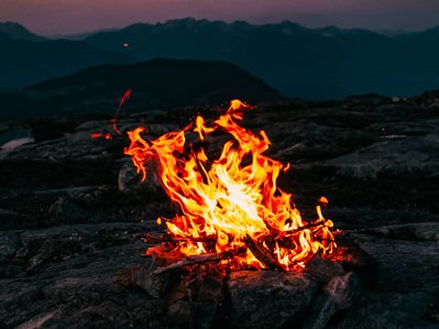Bild zeigt ein Lagerfeuer in natürlicher Umgebung – es geht um die Geschichte der Heizung.