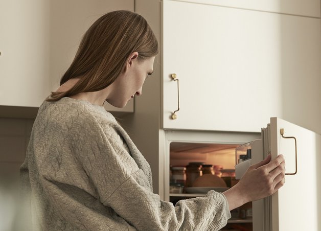 Bild zeigt Frau, die in den Kühlschrank schaut – Thema: Stromverbrauch von Kühlschränken.