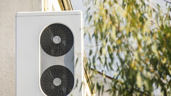 Eine Wärmepumpe steht vor einer Hauswand