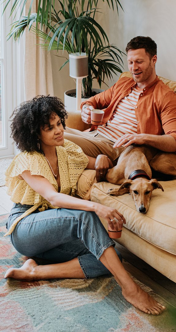Ein Paar sitzt entspannt im modernen Wohnzimmer. Ein Wärmestrom Tarif sorgt für komfortable, nachhaltige Wärme.