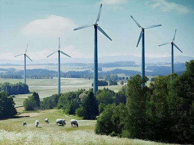 Bild zeigt Windräder umgeben von Feldern – Thema: alternative Energiequellen.
