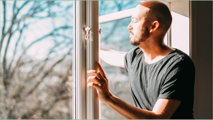 Bild zeigt einen Mann vor winterlichem Fenster als Stimmungsbild zum Thema Gasverbrauch vier Personen