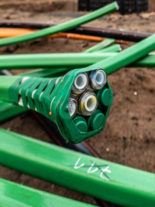 Nahaufnahme von Glasfaserkabeln in Grün. Zeigt Fortschritt beim Glasfaserausbau für bessere Konnektivität in Südhessen.