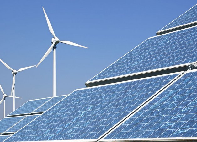 Photovoltaikmodule und Windkraftanlagen in Landschaft; eine Kombination erneuerbarer Energien, wichtig für den Strommix Deutschland.