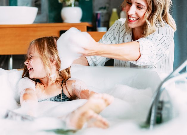 Bild zeigt eine Frau, die ihre Tochter badet, als Symbolbild für Warmwasser-Kosten
