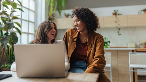 Zwei Frauen im Gespräch, gemütliche Atmosphäre mit Pflanzen und Laptop. Symbolisiert Informationen zu Formularen und Services für ENTEGA Kunden.