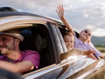 Bild zeigt ein Auto mit einem Mann und zwei Kindern – Thema: KFZ-Steuer fürs Elektroauto.