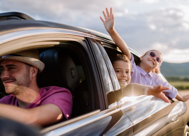 Bild zeigt ein Auto mit einem Mann und zwei Kindern – Thema: KFZ-Steuer fürs Elektroauto.