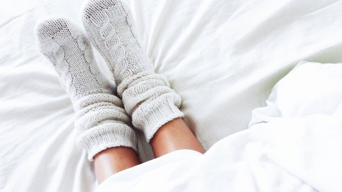 Bild zeigt ein Paar Füße in Wollsocken als Symbolbild für wohlige Wärme nach dem Erneuern der Gasheizung