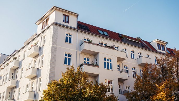 Weißes Wohngebäude mit mehreren Balkonen in einer Stadt. Repräsentiert Informationen von ENTEGA für Vermieter zu Glasfaser im Mehrfamilienhaus.